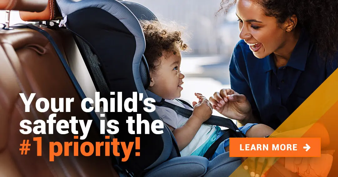 A mother putting her baby in a child car seat