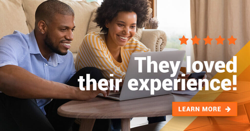 Happy couple look at the computer screen smiling