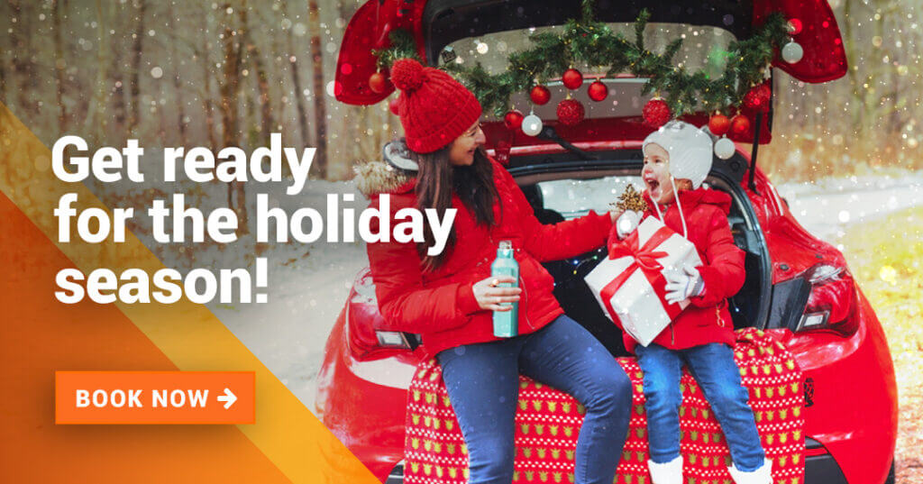 Mom with her daughter giving her Christmas present in the back of the car in a snowy setting